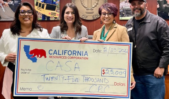 People holding a large check at Casa of Kern County